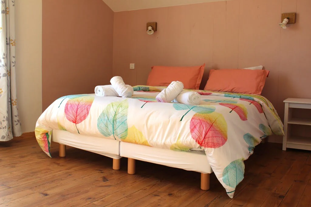 Chambre double dans les tons roses à l'étage de la location de vacances