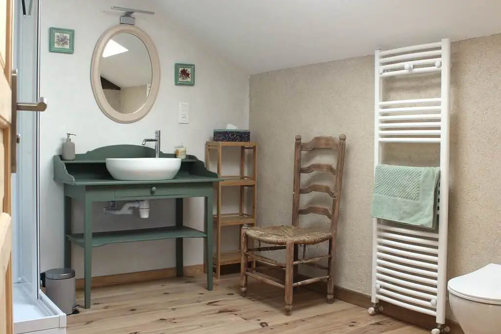 Espace douche mêlant modernité et mobilier authentique dans le Gîte la Méniquette